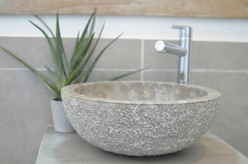 a bowl sink sitting on a counter in a bathroom at Maison d'Hôtes Les Petites Terres in Sainte-Marie-de-Ré