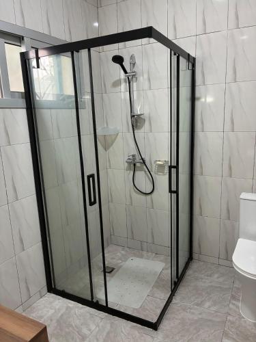 a shower with a glass door in a bathroom at Maison indépendante avec jardin in Abidjan