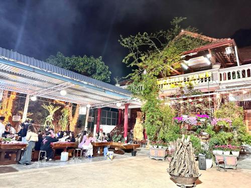 a group of people sitting at tables outside a restaurant at Moc Chau Town - Homestay in Mộc Châu