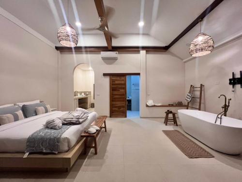 a bedroom with a tub and a bed and a bath room at Haad Yao Bayview Resort & Spa - SHA plus Certified in Haad Yao