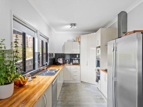 a kitchen with white cabinets and a stainless steel refrigerator at Inn Seaclusion in Devonport