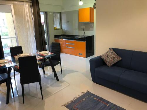 a living room with a couch and a table and a kitchen at Goa stays in Anjuna