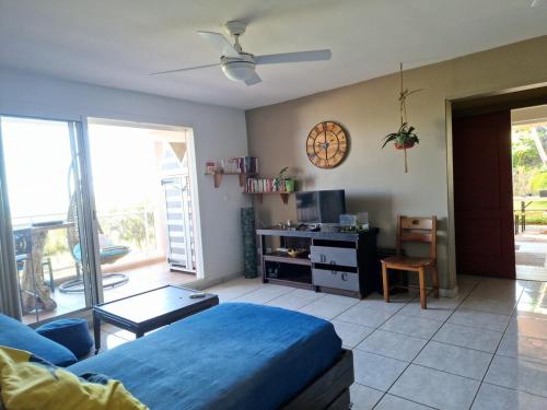 ein Wohnzimmer mit einem blauen Bett und einem Tisch in der Unterkunft Petit jardin suspendu in Petite Île