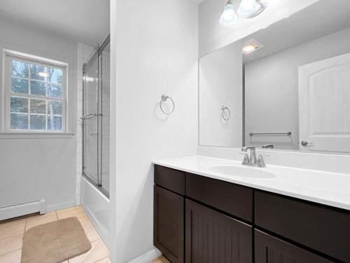 un bagno bianco con lavandino e specchio di The Mendon House a Killington