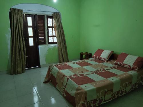a bedroom with a bed in a room with a window at Foreign Home Stay in Katugastota