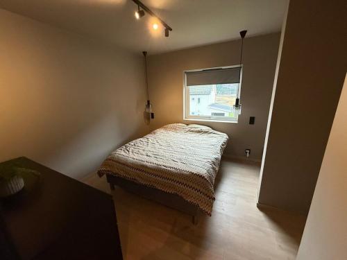 a room with a bed in a room with a window at Nyoppusset leilighet til leie in Isfjorden