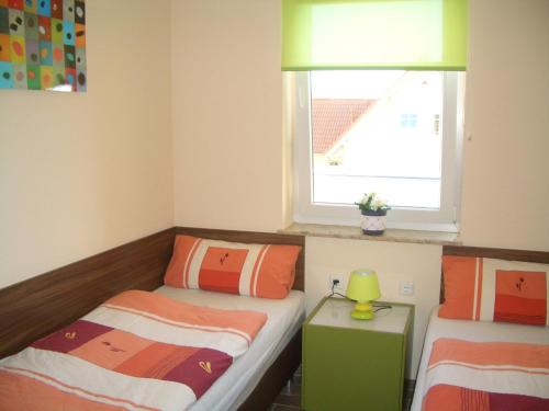 ein kleines Schlafzimmer mit 2 Betten und einem Fenster in der Unterkunft Ferienwohnung Rerik in Rerik