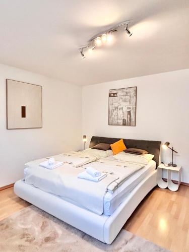 een slaapkamer met een groot wit bed in een kamer bij Flower House - Souterrain with Garden in Mölbling