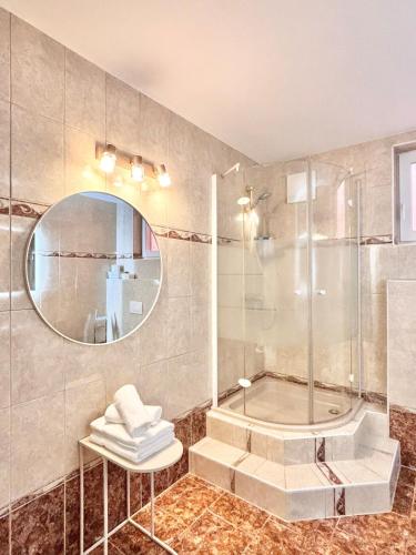 een badkamer met douche, wastafel en spiegel bij Flower House - Souterrain with Garden in Mölbling