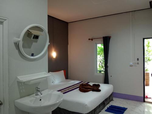 een badkamer met een bed, een wastafel en een spiegel bij Lanta Beautiful beach house in Koh Lanta