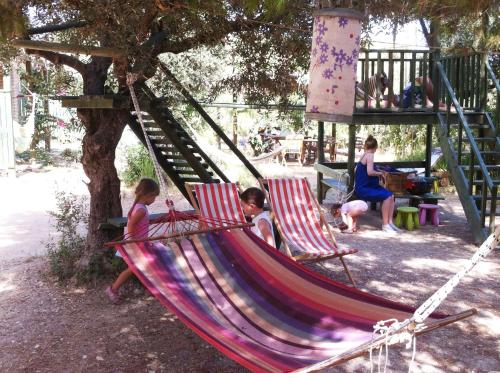three children sitting in a hammock in a playground at Alegria Villas Complex in Vasilikos