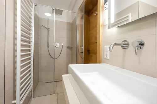 a white bathroom with a shower and a sink at Mountain Lodge Leogang-Premium Apartment, Balkon, Bergblick, Kamin, Sauna in Leogang