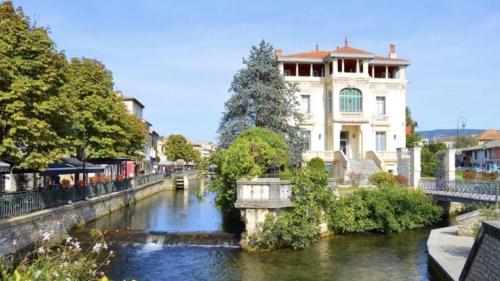 een gebouw naast een rivier in een stad bij Le Coeur de L'Isle, Cosy, Hypercentre, Clim, Wifi, TV, Netflix in LʼIsle-sur-la-Sorgue