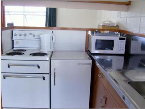 a kitchen with a white stove and a microwave at Motel Six in Hamilton