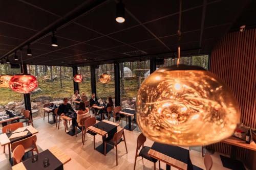 een restaurant met een grote gouden schaal die aan het plafond hangt bij Aurora Igloo, Sauna Spa & Dinner by Invisible Forest Lodge Adults Only in Rovaniemi
