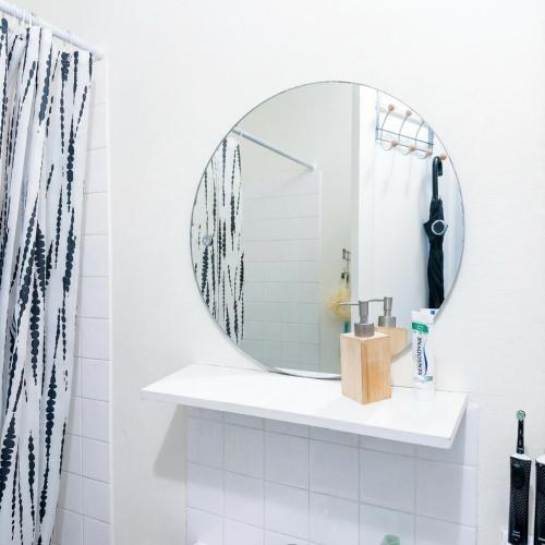 een badkamer met een ronde spiegel aan de muur bij A spacious room in a strategic area in Montrouge