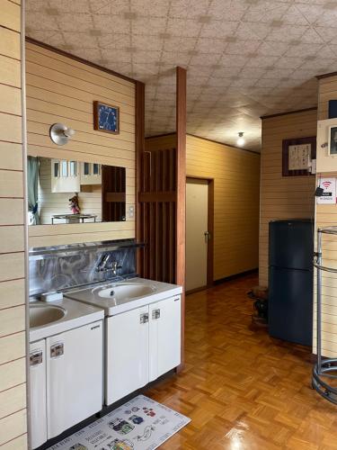 een keuken met 2 wastafels in een kamer bij オイソ in Iiyama