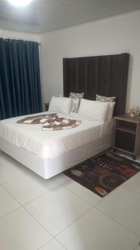 a large white bed in a room with at KLAAK hotel and Apartments in Ga-Masamothane