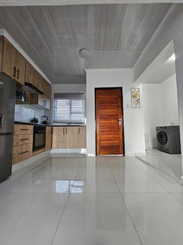 an empty kitchen with a wooden door in a room at KLAAK hotel and Apartments in Ga-Masamothane