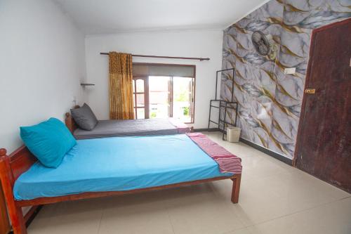 una camera da letto con un letto e un grande dipinto sul muro di The Spring Holiday a Mirissa