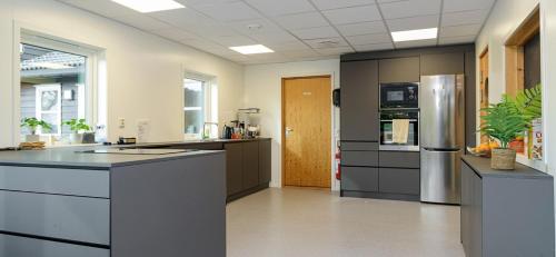 a large kitchen with stainless steel appliances in a room at Siggjo Guesthouse Bømlo and Stord in Mosterhamn