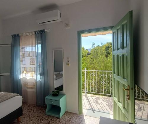une chambre avec une porte ouverte sur un balcon dans l'établissement Kalimera Aegina, à Agia Marina