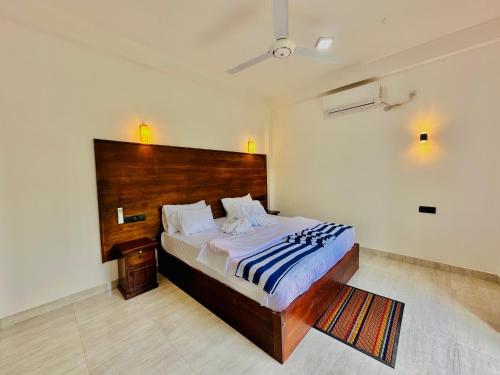 een slaapkamer met een groot bed met een houten hoofdeinde bij In Dream Villa in Rekawa