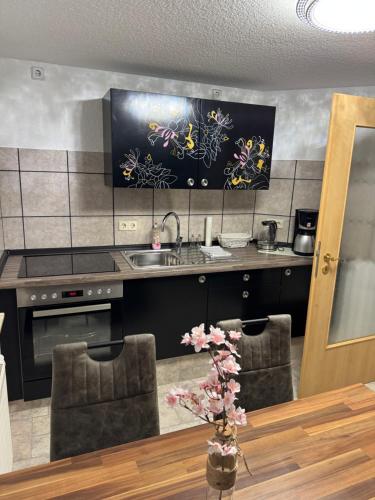 een keuken met een wastafel en een aanrecht met 2 stoelen bij Ihr Zuhause am Dom Stilvoll übernachten im Herzen von Halberstadt in Halberstadt