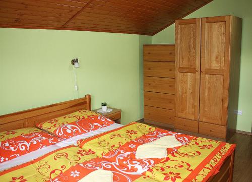 a bedroom with a bed and a wooden cabinet at Chata Dominika - Tále in Bystrá