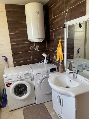 a bathroom with a washing machine and a sink at Murat villa in SJJ