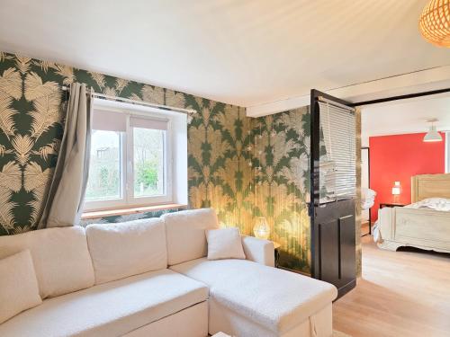 een woonkamer met een bank en een slaapkamer bij Aux Berges Du Mont - Parking, 10 min Mont-Saint-Michel & Jardin in Pontorson