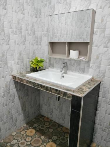 a bathroom with a sink and a mirror at ปารมีฟาร์มสเตย์ in Ban Chao Nam