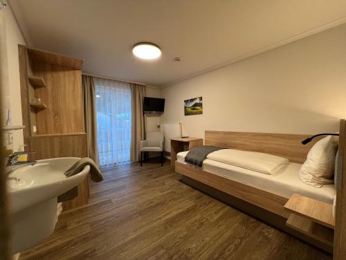 una camera d'albergo con un letto e un lavandino di Haus Luise a Bad Hindelang
