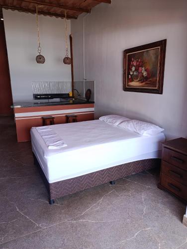 a large bed in a bedroom with a piano at Divas do mar kitnet 7 in Ilhéus