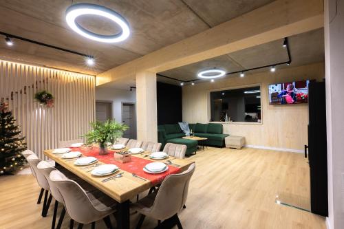 a dining room with a table with chairs and a christmas tree at Chalet Horizont in Ižipovce