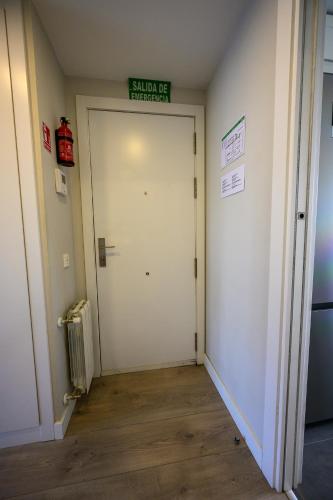 a hallway with a white door with a sign on it at Apartamento Cervantino in Alcalá de Henares