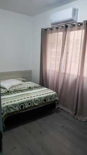 een slaapkamer met een bed en een gordijn bij Hotel leo in Pelotas