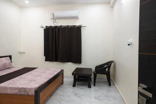 a bedroom with a bed and a chair and a desk at Hotel Pampa Sarovar in Chhatarpur