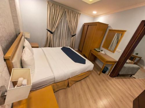 een hotelkamer met een bed en een spiegel bij صفاء المسكن in Dammam