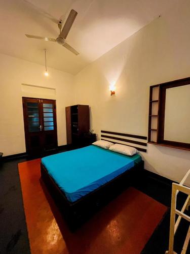 a bedroom with a blue bed in a room at Mango Three Resort in Anuradhapura