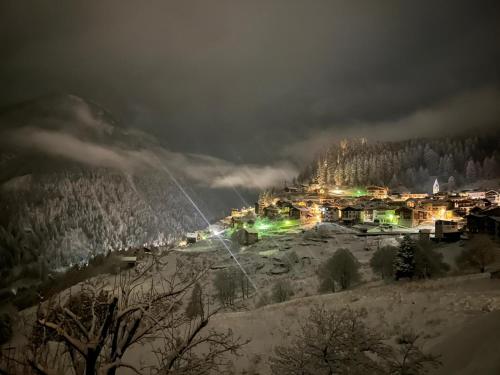 een stad verlicht in de sneeuw 's nachts bij Un balcone sulla Val di Pejo in Peio