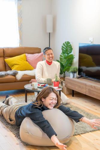 a woman laying on the floor in a living room at tazuraya-suehiro-一棟貸切-無料駐車場 in Takamatsu