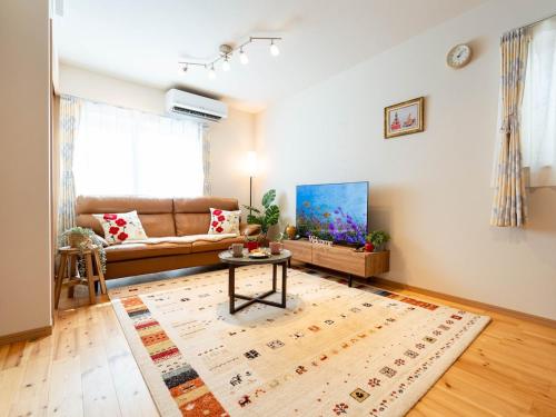 a living room with a couch and a table at tazuraya-suehiro-一棟貸切-無料駐車場 in Takamatsu