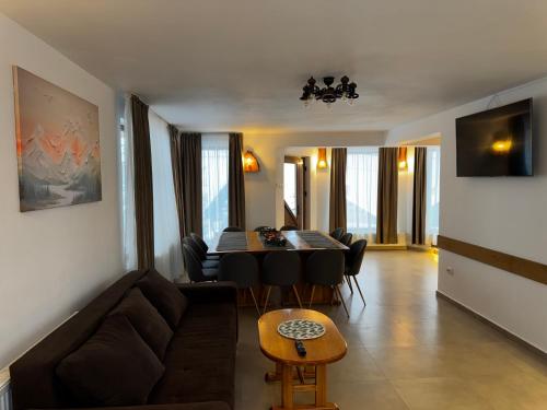 ein Wohnzimmer mit Sofa und Tisch in der Unterkunft Pensiunea Pusu in Ranca