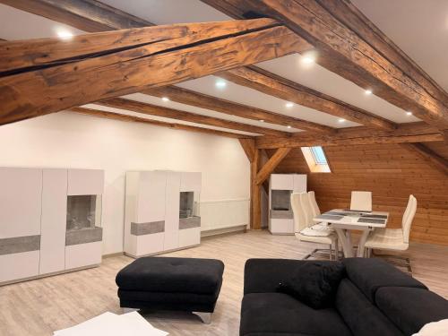 un soggiorno con un divano nero e un tavolo di Zentrale Erbendorfer Studiowohnung a Erbendorf