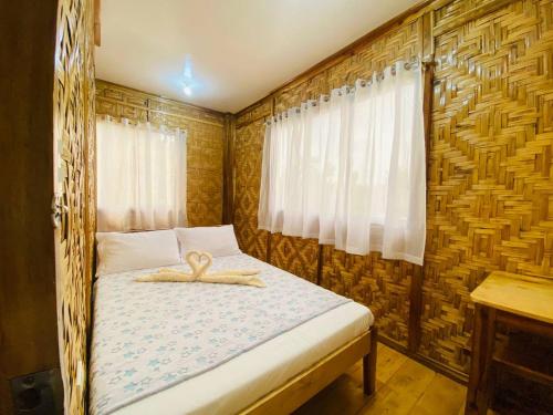 a small bedroom with a bed with a wooden frame at The Tribe Apartment in Port Barton
