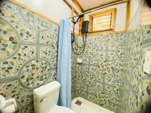 a bathroom with a toilet and a shower at The Tribe Apartment in Port Barton