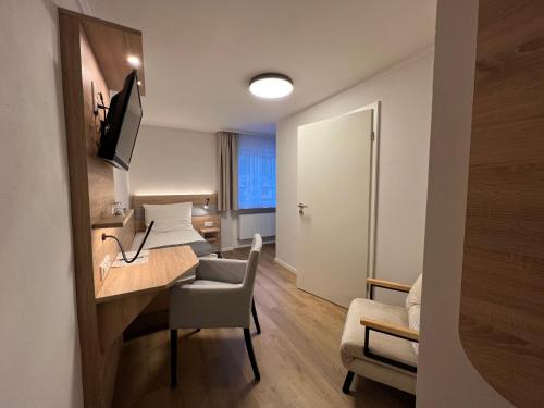 een hotelkamer met een bureau en een kamer met een bed bij Haus Luise in Bad Hindelang