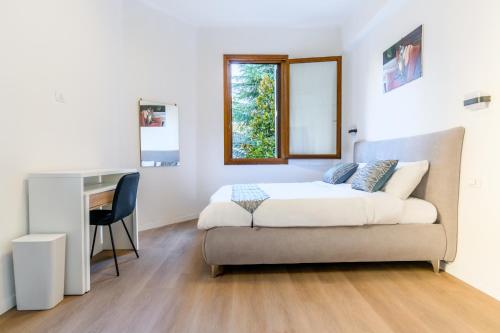 a bedroom with a bed and a desk in it at Ipin Home in Mestre