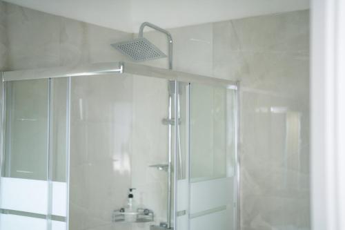 a white bathroom with a shower and a sink at Ipin Home in Mestre